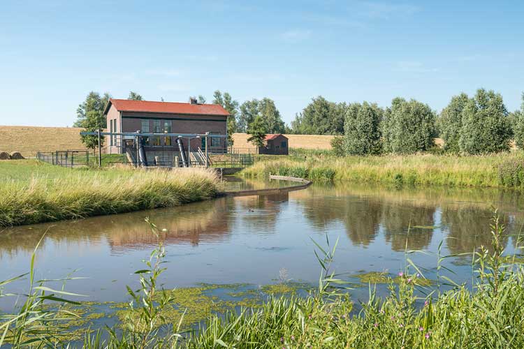 Waterpompstation naast binnenwater in de polder